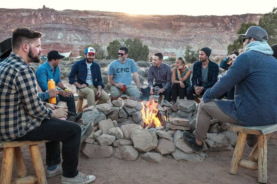 a group of people around a fire laughing and showing Healthy realtionship