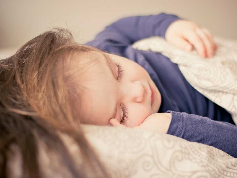 A child sleeping in a bed shows quality sleep.